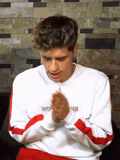 a young man wearing a white and red sweatshirt with the word wr on it