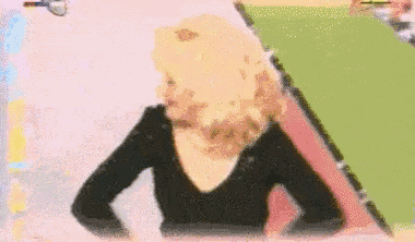 a woman in a black shirt is sitting in front of a pink and green triangle .