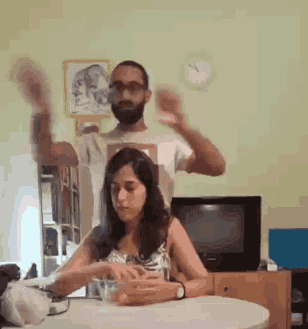 a man and a woman are dancing in front of a television