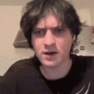 a close up of a man 's face with a black shirt on .