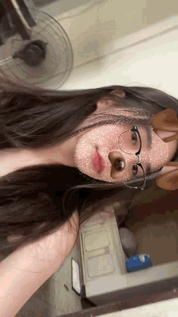 a girl wearing glasses and a dog mask looks at the camera