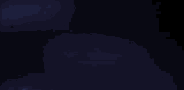 a man in a black hoodie is sitting in front of a city skyline