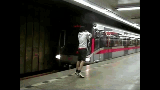 a man standing in front of a train with a sign that says ' aida ' on it