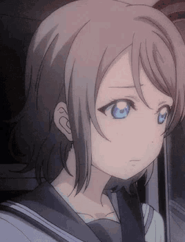 a close up of a girl 's face with a sad look on her face