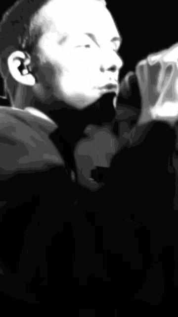 a blurry black and white photo of a person 's face with a superman logo in the background