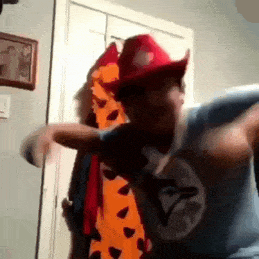 a man wearing a fireman 's hat is holding another man 's arm in a room .