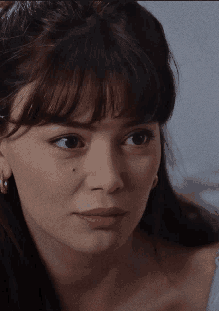a close up of a woman 's face with earrings