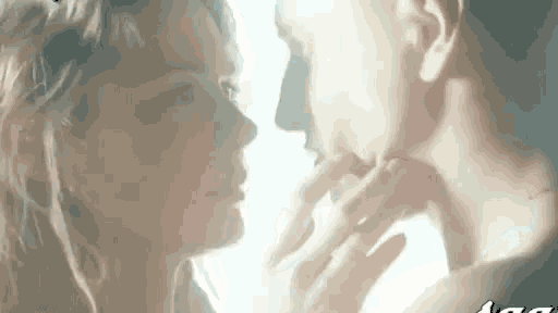 a man and a woman are touching each other 's faces and looking at each other .