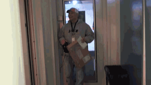 a man is carrying a cardboard box with the word usps on it