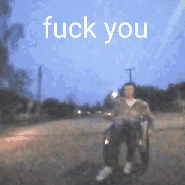 a blurry picture of a person in a wheelchair with the words " fuck you " above them