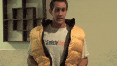 a man is wearing a yellow vest that says safety vest on it