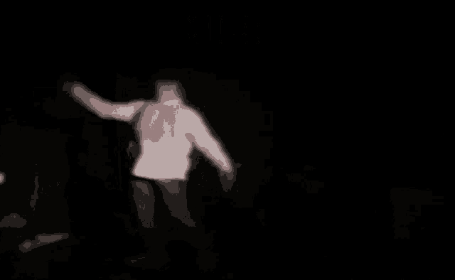 a blurred image of a person in a white hoodie in a dark room with the word umiera above them .