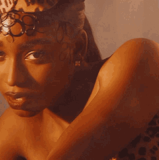 a close up of a woman wearing a leopard print dress and a hat