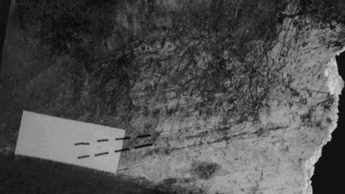 a black and white photo of a rock with a piece of paper that says zzz