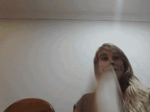 a woman with a tattoo on her face is smoking a cigarette