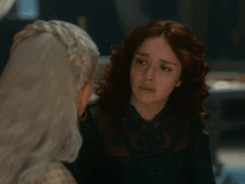 two women are looking at each other with their eyes closed and one has a sad look on her face