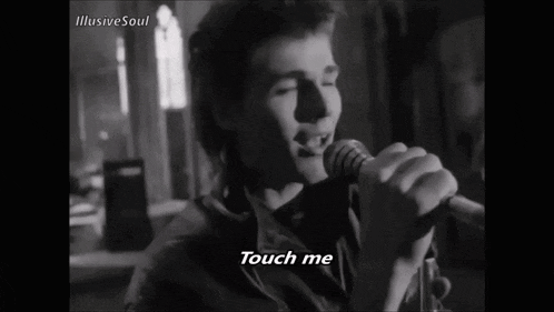 a black and white photo of a man playing a guitar with the words touch me written below him