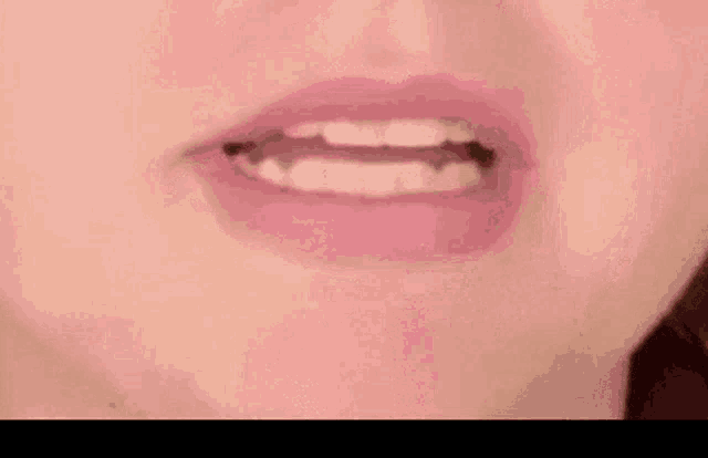a close up of a woman 's mouth with white teeth and pink lips