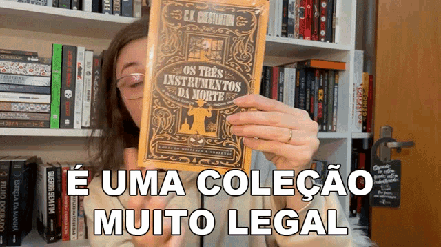 a woman is holding a book that says " os tres instrumentos da morte "