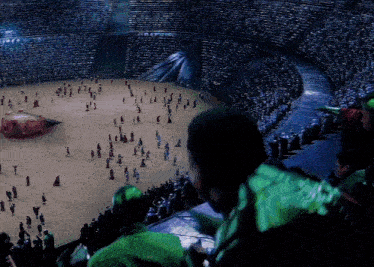 a crowd of people are gathered in a stadium watching a show