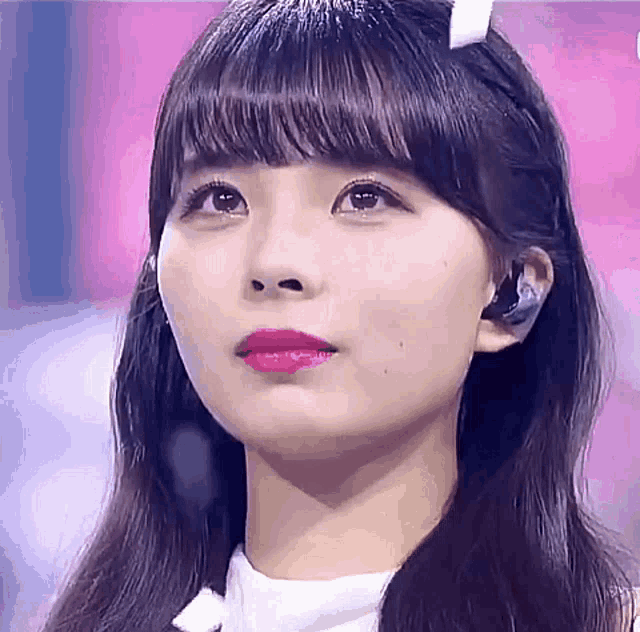 a close up of a woman 's face with red lipstick and headphones on a stage .