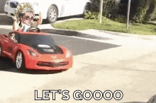 a red toy car with the words let 's goooo written on the bottom