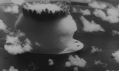 a black and white photo of a nuclear bomb explosion in the sky