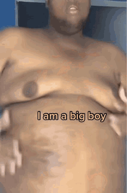 a man without a shirt has the words " i am a big boy " on his chest