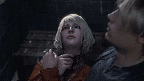 a man and a woman are looking at each other in a dark room