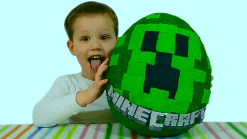 a young boy holds a green minecraft egg in his hands