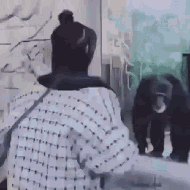 a woman is standing in front of a chimpanzee in a zoo enclosure .