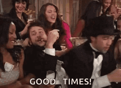 a group of people are sitting at a table with a man in a tuxedo and top hat .