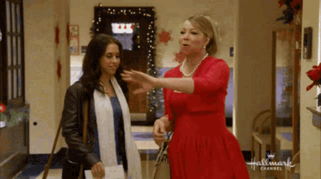 two women are standing in a hallway with a hallmark channel logo