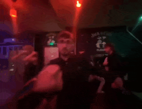 a blurry picture of people dancing in a dark room with red lights