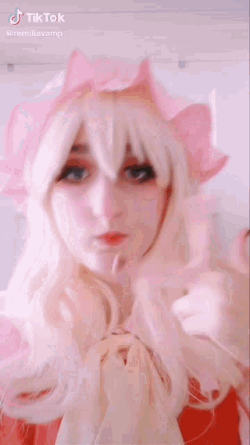 a woman with blonde hair and a pink crown on her head is making a face .