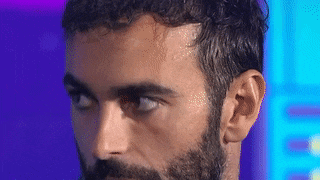 a close up of a man 's face with a beard .