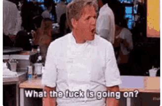 a man in a chef 's uniform is standing in front of a crowd and saying what the fuck is going on .