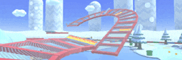 a red roller coaster in a snowy area with a blue sky in the background