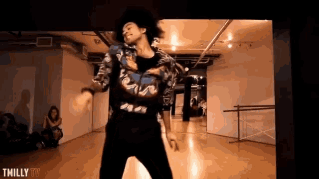 a man is dancing in a dance studio with tmilly tv written on the bottom of the screen