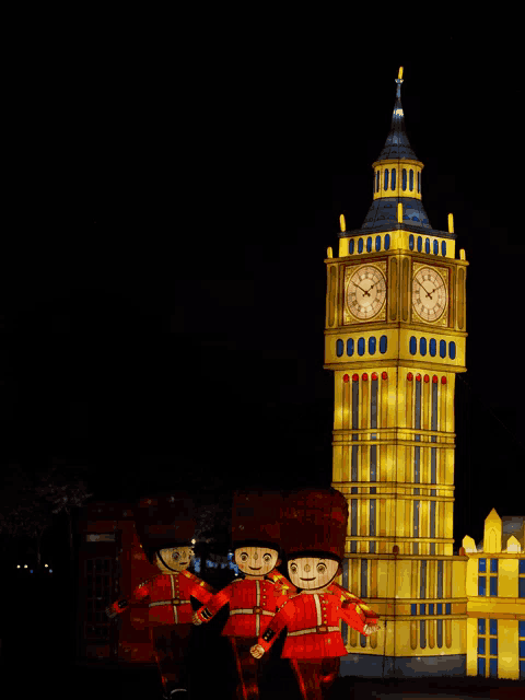 the big ben clock tower is lit up at night with soldiers standing in front of it
