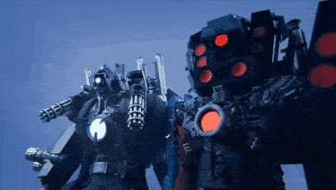 two robots are standing next to each other and one has a red light on the back of it