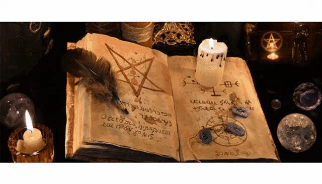 an open book with a pentagram on it and a candle on it