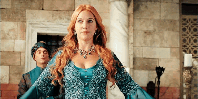 a woman with red hair wearing a blue dress
