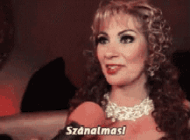 a woman is talking into a microphone and the word szanalmas is on the bottom