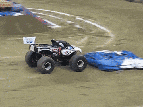 a monster truck is doing a trick on the dirt
