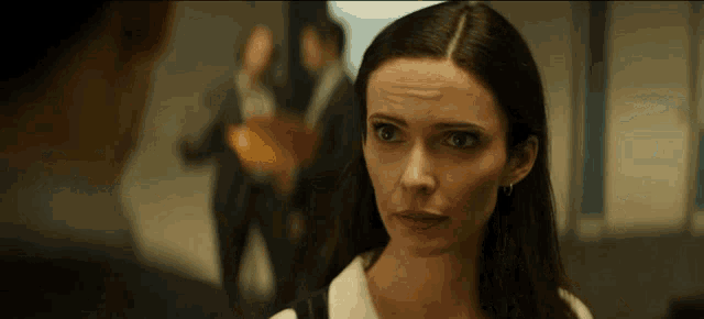 a woman with a serious look on her face is talking to a man