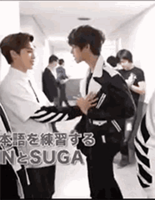 a group of men are standing next to each other in a hallway .