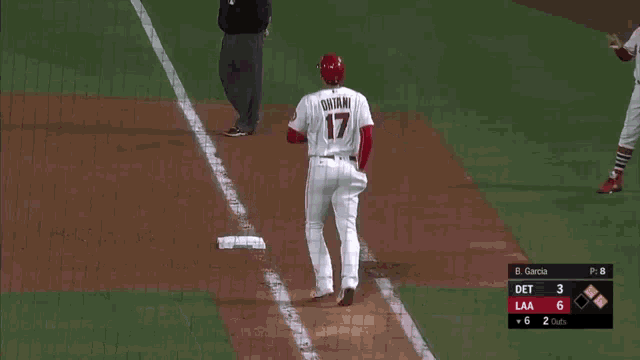 a baseball player with the number 17 on his jersey stands on the field
