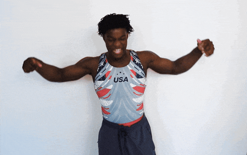 a man wearing a usa tank top is standing with his arms outstretched