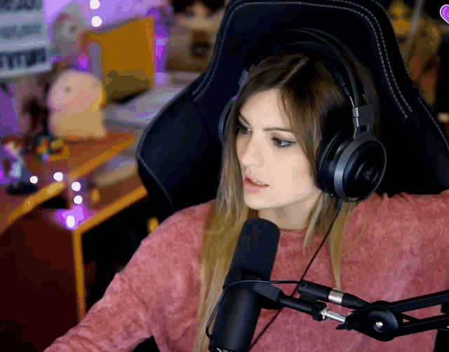 a woman wearing headphones is sitting in front of a microphone and a sign that says " i love you "